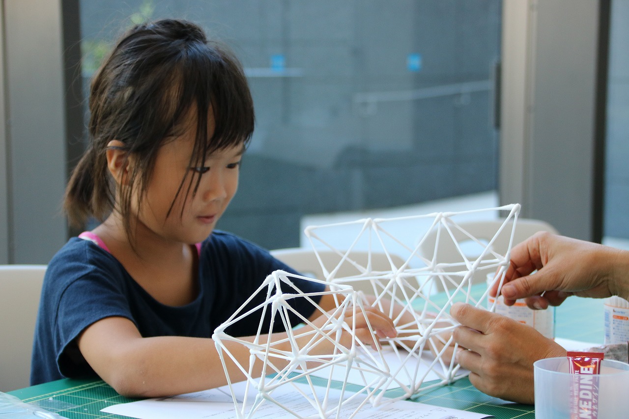 真剣な表情で立体構造の模型を作る子供
