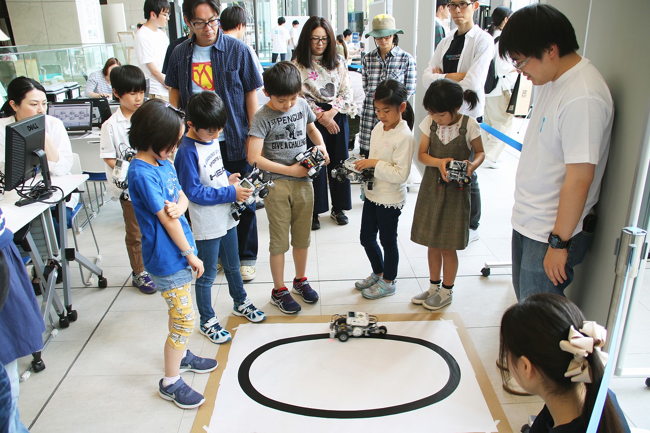 プログラムどおり動くかロボットカーを凝視する子どもたち
