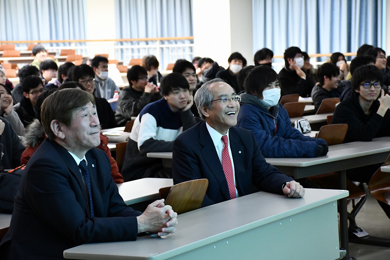 ユーモアあふれる作品に笑みをうかべる西村学長（写真左）と栗山村長