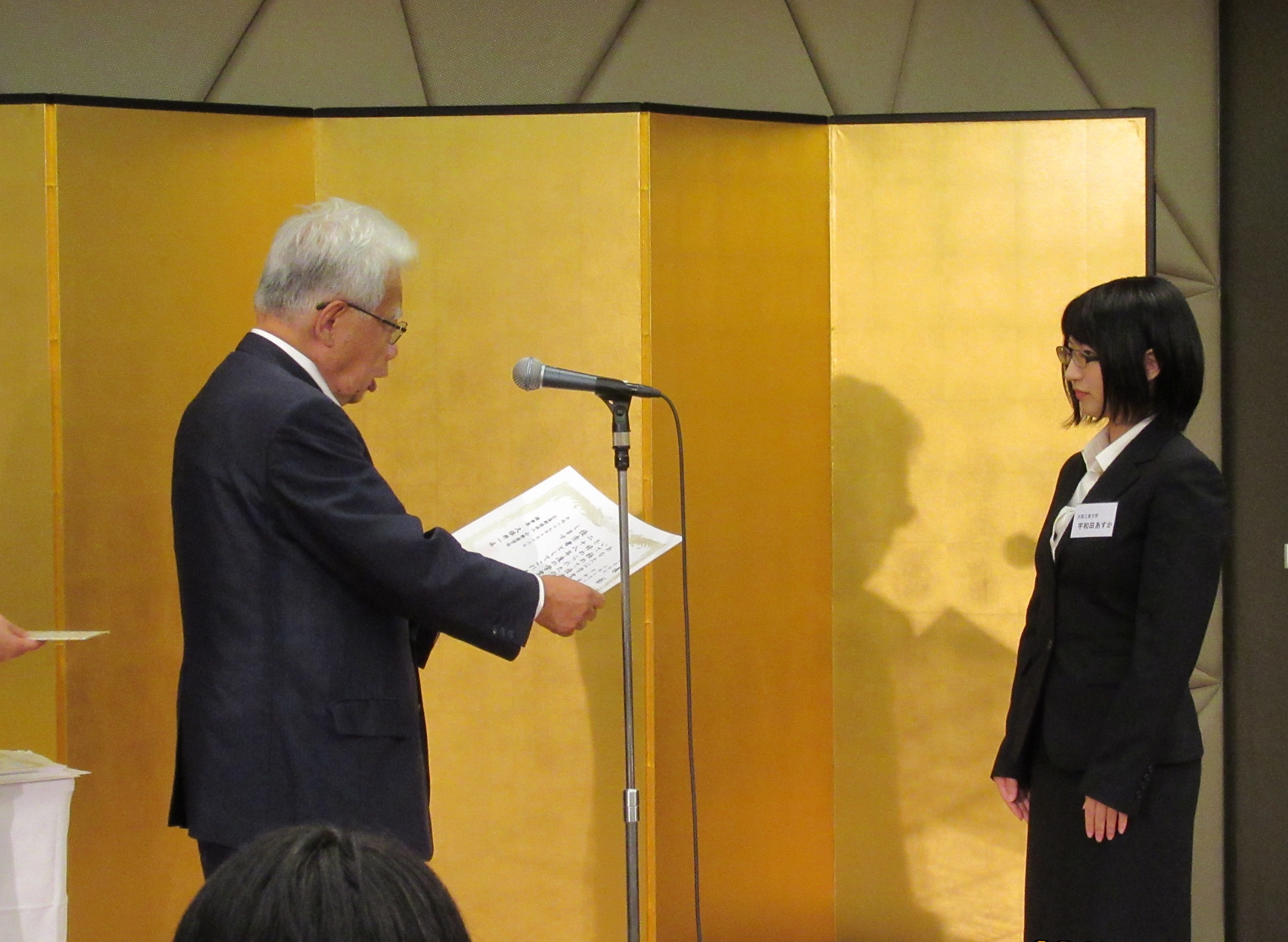 同奨学会の久保井一匡理事長から表彰を受ける宇和田さん（写真右）