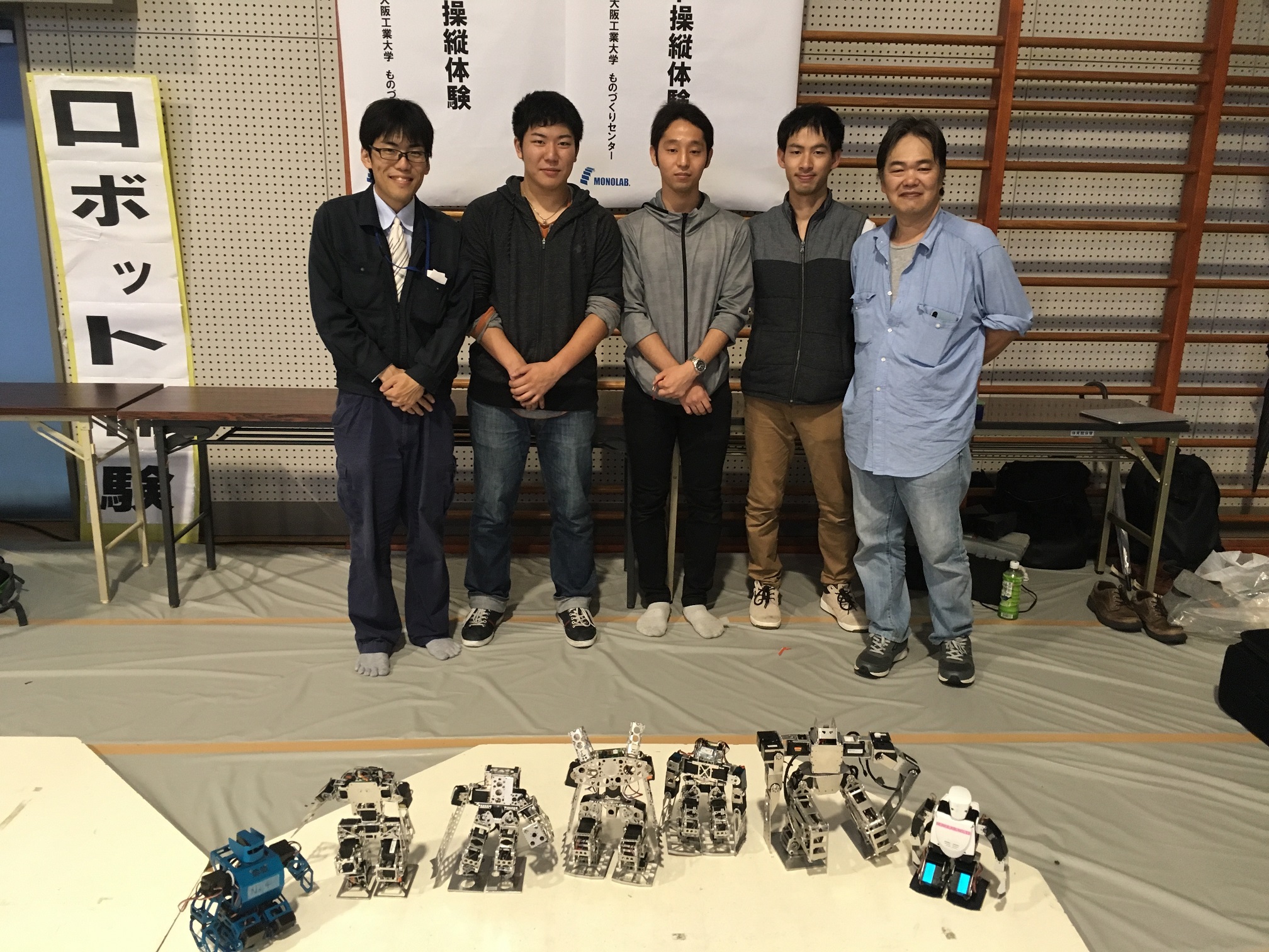 イベントに出展したロボットプロジェクトの学生有志と指導教員の近藤隆路技師（写真左）  