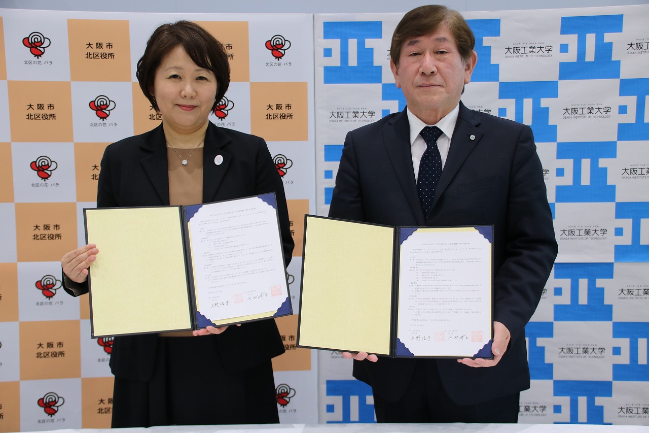 協定書にサインを交わした西村学長（写真右）と上野区長
