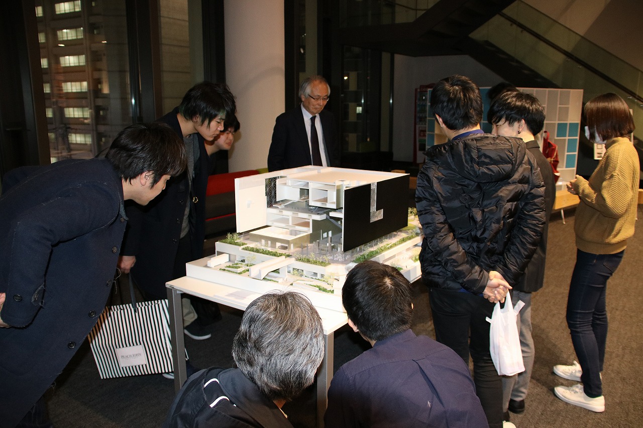 特別展示「（仮称）大阪新美術館」の完成イメージ模型を覗きこむ参加者ら
